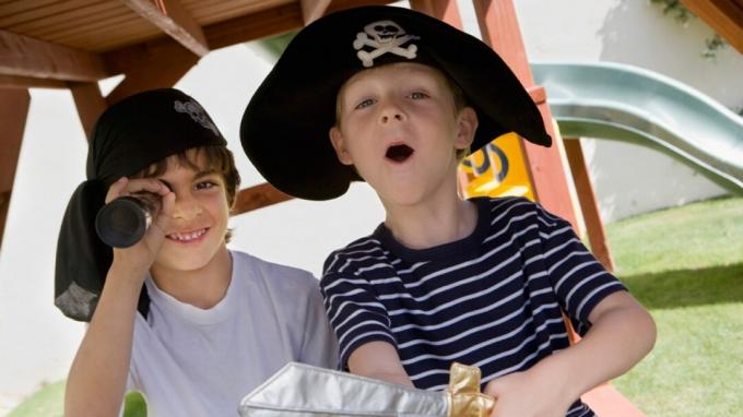 Zwei Jungen mit ADHS spielen Piraten auf dem Spielplatz in Kostümen